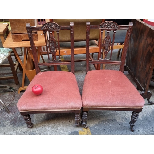 436 - Pair of Victorian mahogany side chairs with carved backs and upholstered seats. The chairs feature t... 