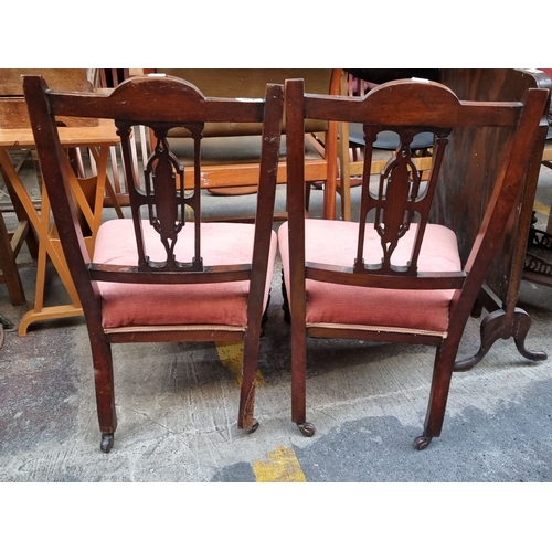 436 - Pair of Victorian mahogany side chairs with carved backs and upholstered seats. The chairs feature t... 