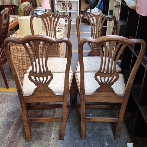 442 - Set of four oak dining chairs with carved backs and upholstered seats, featuring intricate patterns ... 