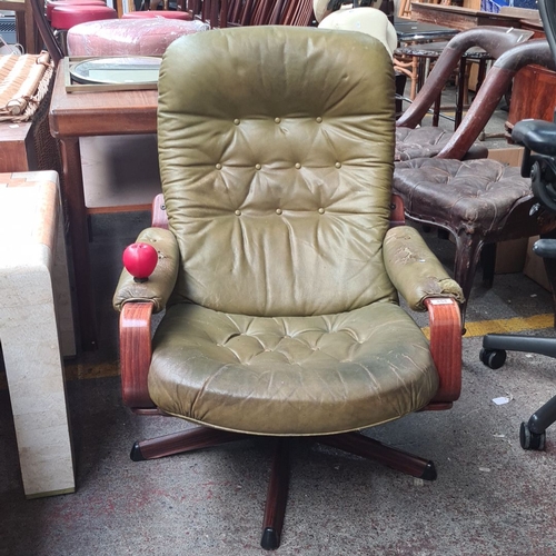 454 - Star Lot : A Swedish G Mobel Mid-Century Modern upholstered swivel chair with green leather and rose... 