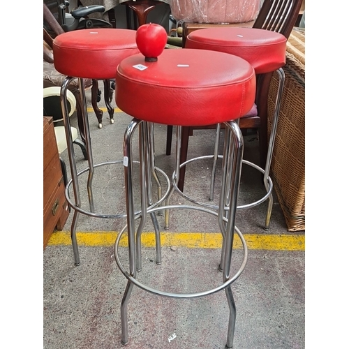 458 - Set of three red retro bar stools with chrome legs. Retro design. These are very cool.