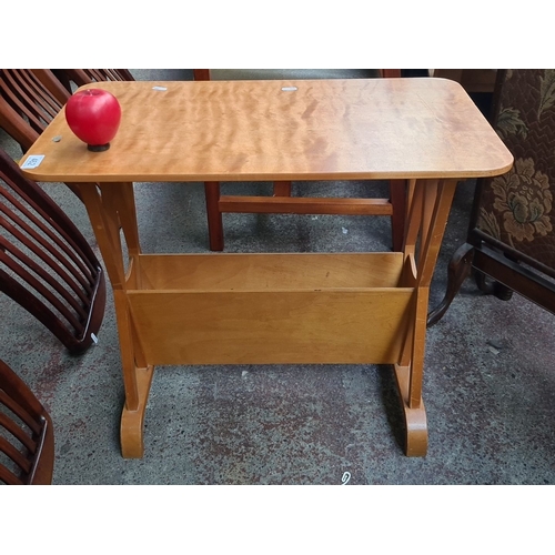 462 - A mid century  magazine table with integrated shelf, made from light-toned wood, featuring curved le... 