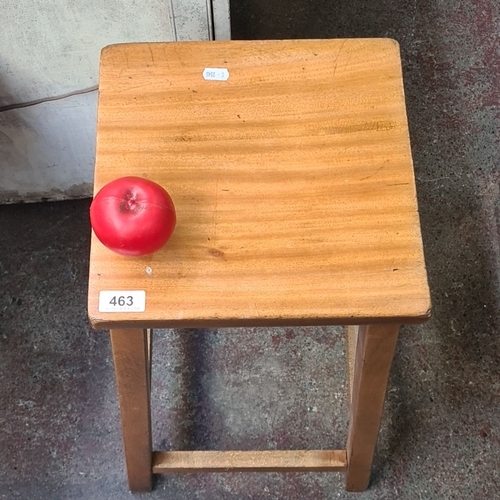 463 - Small wooden stool crafted from golden oak, featuring a simple, sturdy design with four square legs ... 