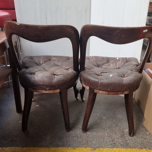 478 - Pair of Victorian balloon-back chairs with tufted leather seats, featuring carved mahogany frames an... 