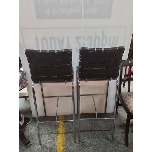 483 - Set of two tall Modern bar stools. Feature chrome frames with woven black leather backrests and seat... 