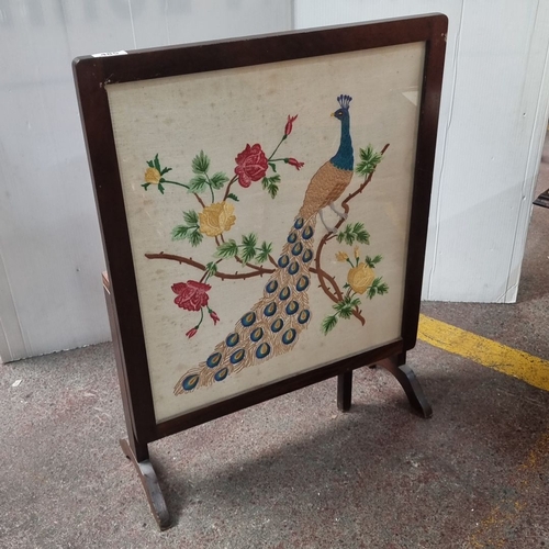 485 - Mahogany fire screen with pop up table with embroidered peacock and floral design on top.