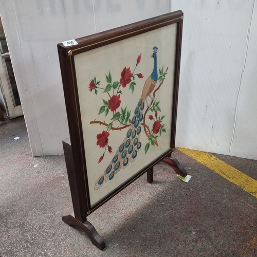 486 - A vintage fire screen with wooden pop up table features a framed embroidered peacock and floral desi... 