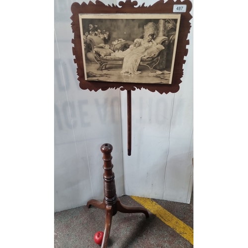 487 - Victorian mahogany adjustable pole screen with an intricately carved frame displaying a black and wh... 