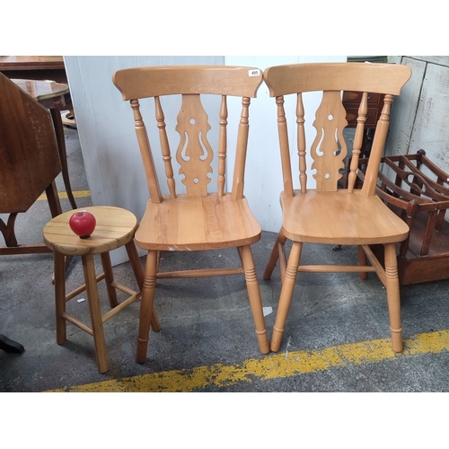 495 - Pair of classic spindle-back chairs crafted from maple wood, featuring decorative backrest cutouts. ... 