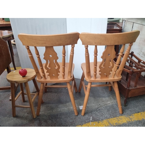 495 - Pair of classic spindle-back chairs crafted from maple wood, featuring decorative backrest cutouts. ... 