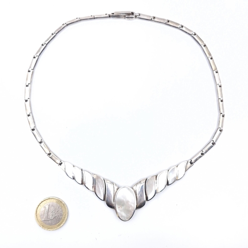 27 - A Sterling Silver necklace with mother of pearl detailing. Length - 36 cms. Weight - 39.89 grams.