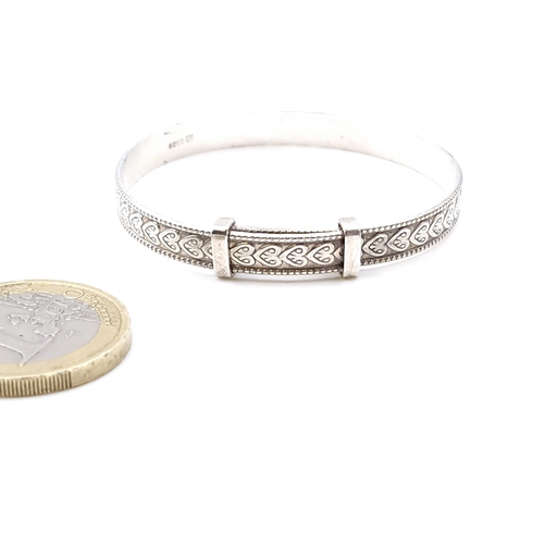 39 - A sterling silver child's expandable bracelet with attractive foliette design to band. Total weight ... 