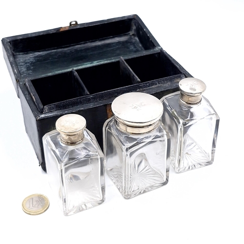 46 - A interesting and unusual antique travelling case containing three glass perfumery bottles with silv... 