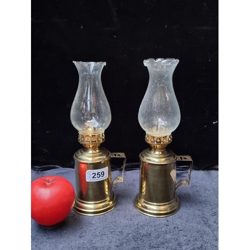 259 - A pair of handsome brass miniature oil lamps with hurricane glass.