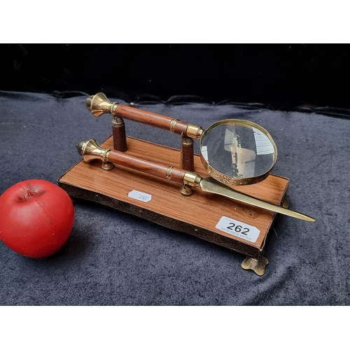 262 - A wood and brass desktop set including letter opener and magnifying spy glass.