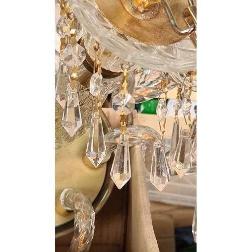 883 - Star lot : A Super chandelier with six arms, gold-tone accents, and adorned with crystal prisms and ... 