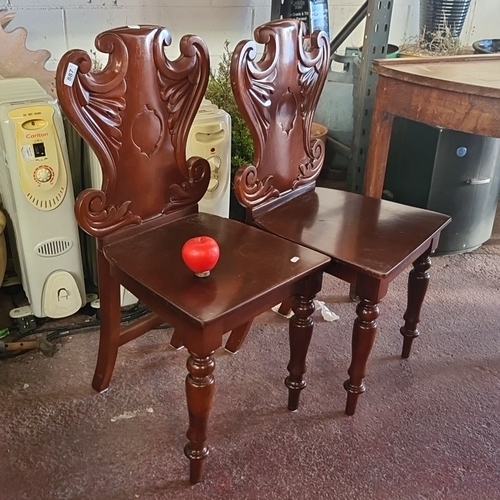 887 - A Pair of Victorian mahogany hall chairs with intricately carved gothic accents and turned front leg... 