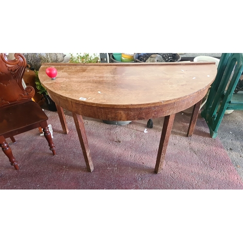 888 - Antique oak half-moon console table with tapered legs and raised edge.