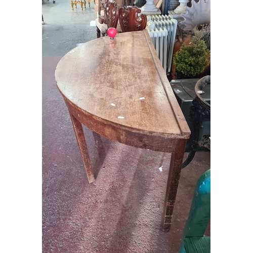 888 - Antique oak half-moon console table with tapered legs and raised edge.