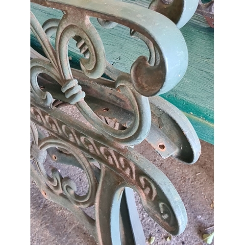 890 - Ornate cast iron bench ends with intricate scrollwork design. Vintage aesthetic with green finish.