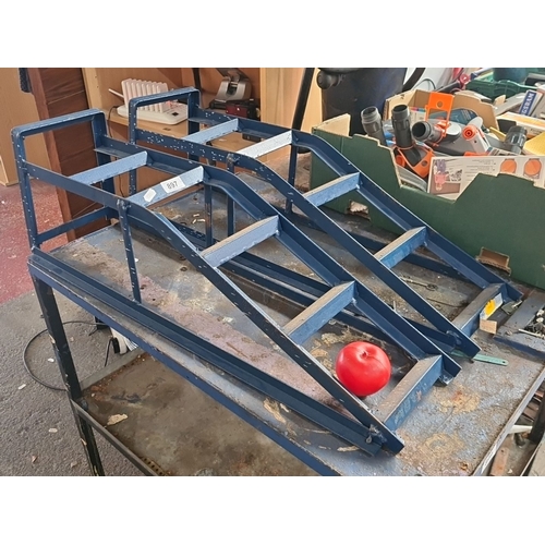 897 - Two blue-painted car ramps with rugged construction and angular supports for stability.