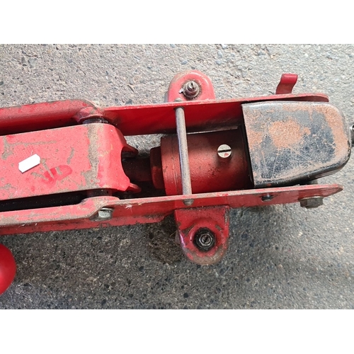 900 - Vintage red hydraulic floor jack with lifting handle, steel construction, manual operation.