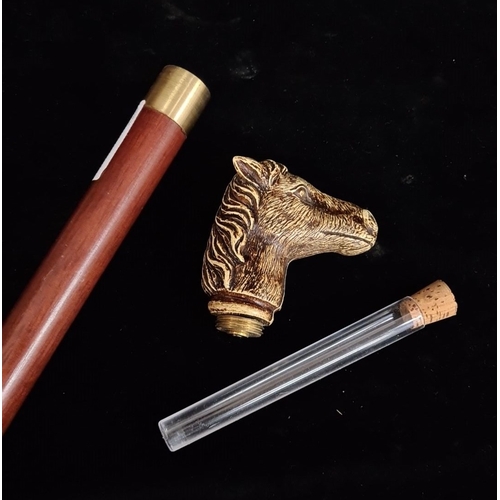 918 - Wooden tipple stick walking cane featuring a brass horse head handle, the head removes to reveal a f... 