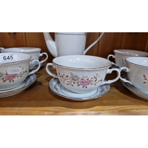 645 - Porcelain teaware set with floral pattern and gold trim, includes multiple plates, teacups with sauc... 