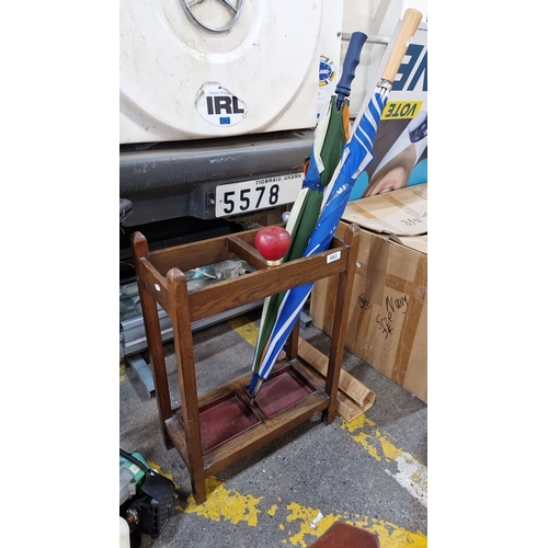 683 - A handsome oak 1940s umbrella stand with dual drip trays. With a couple of umbrellas thrown in.