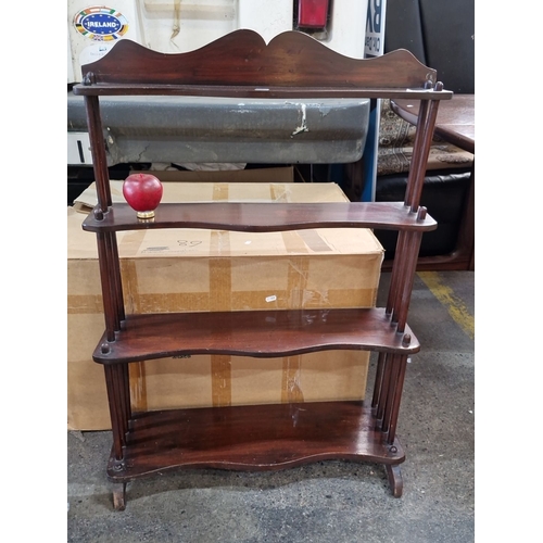 686 - Four-tier mahogany wall shelf with scalloped edges and turned supports.