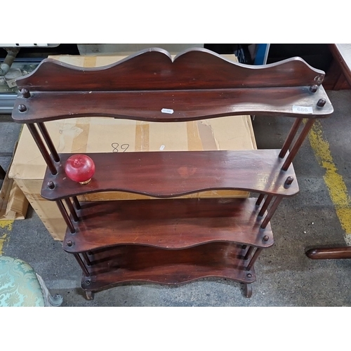 686 - Four-tier mahogany wall shelf with scalloped edges and turned supports.