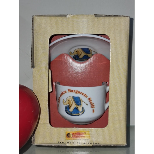 755 - A new in box 150th anniversary Steiff elephant cup and saucer.