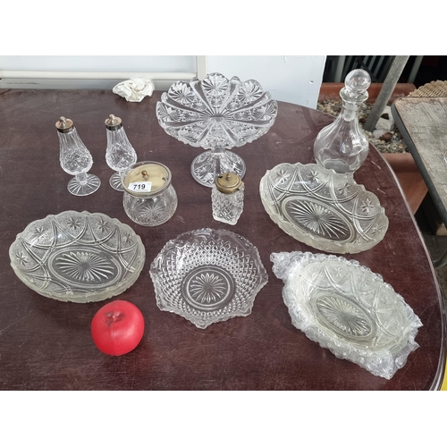 719 - A collection of cut glass pieces including a pedestal cake dish for five serving dishes and a decant... 