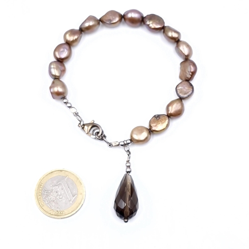 514 - A fresh water baroque pearl bracelet with a smoky quartz accent.  Clasp marked 925. Weight - 19.38 g... 