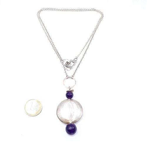 520 - A sterling silver disc pendant set with amethyst stone detailing with interlocking clasp. Length of ... 