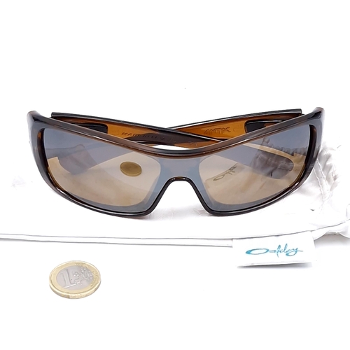 542 - A pair of Oakley wrap around sunglasses with gold tinted frames. Lenses clear.