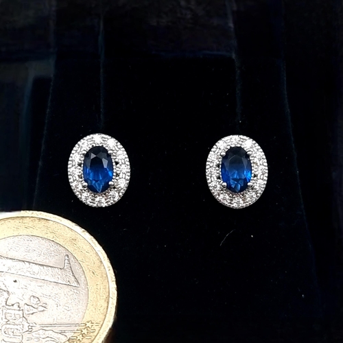 550 - A good pair of blue sapphire stud earrings with gemstone surround mounted in sterling silver. New st... 