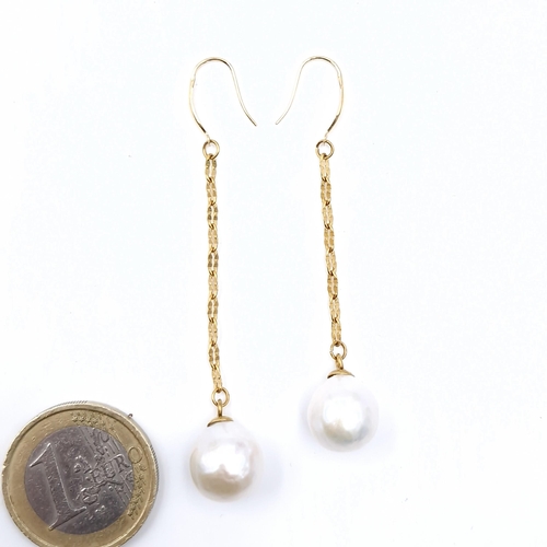 569 - A pretty pair of long 18 carat gold Akoya pearl earrings.