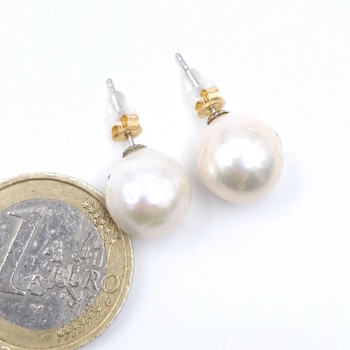 570 - Star lot : A pair of 18 carat gold large akoya pearl stud earrings.