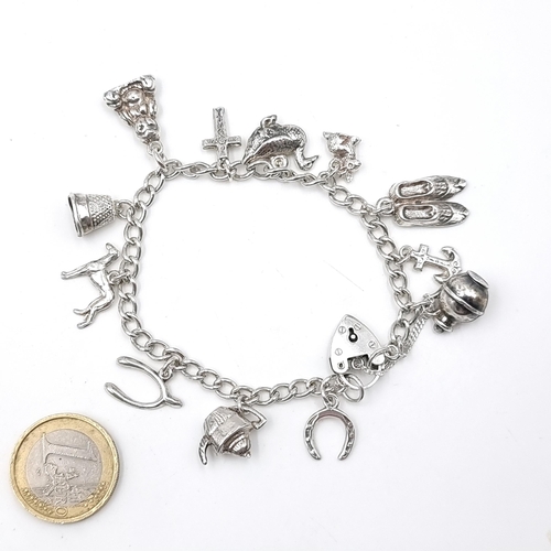 624 - A charming Sterling Silver 1960s charm bracelet. Features a heart padlock with twelve charms and saf... 