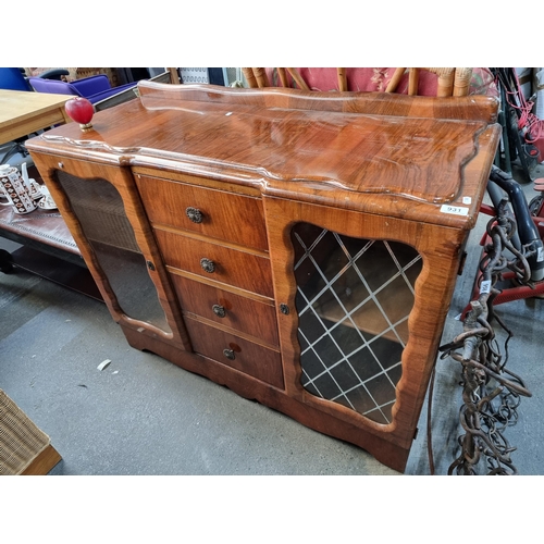 931 - A vintage mahogany sideboard with glass-paneled doors and four central drawers. Features ornate meta... 