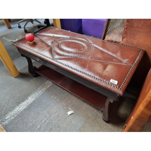 933 - An unique Wooden coffee table with studded brown leather top, featuring intricate geometric and circ... 