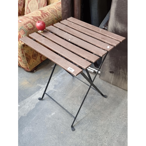 945 - A charming folding patio table with metal frame and wooden slats top. (one slat with repair.)