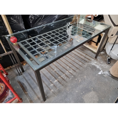 956 - A modern IKEA glass dining table with a metal frame and a model number of 200.228.45. The table feat... 