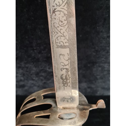 107 - A great example of an Indian talwar sword with a hand guard, etched blade and original sheath.