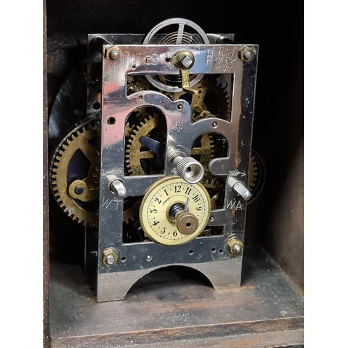 110 - A vintage Junghans wooden mantel clock with brass accents.