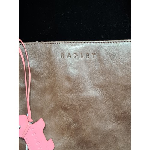 144 - A beautiful ladies brown leather handbag by Radley. In excellent condition. With the classic pink Le... 