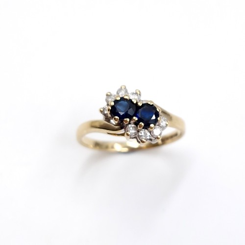 4 - Star lot : A nine carat gold two stone sapphire and diamond ring. Ring size - I 1/2. Weight - 1.7 gr... 