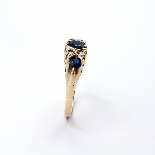 5 - Star Lot : An attractive vintage nine carat gold three stone sapphire & diamond set ring. Size - M 1... 