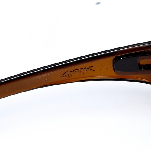 542 - A pair of Oakley wrap around sunglasses with gold tinted frames. Lenses clear.